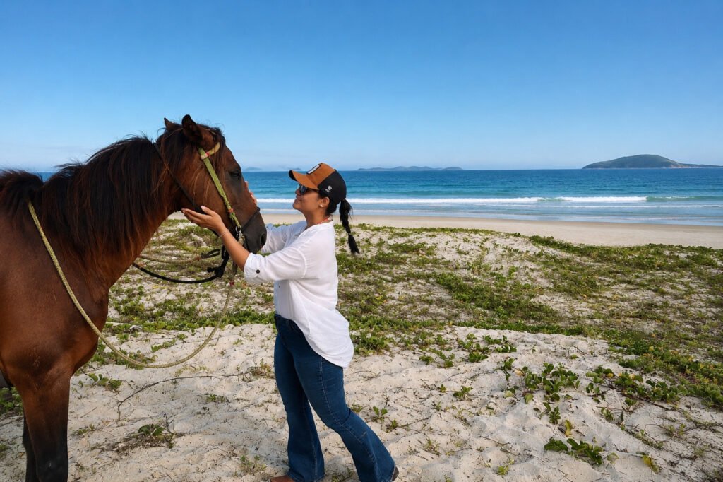 Turista interagindo com cavalo durante passeio na Praia do Peró em Búzios.